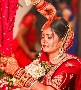 Indian bride and groom in traditional attire sharing an emotional moment